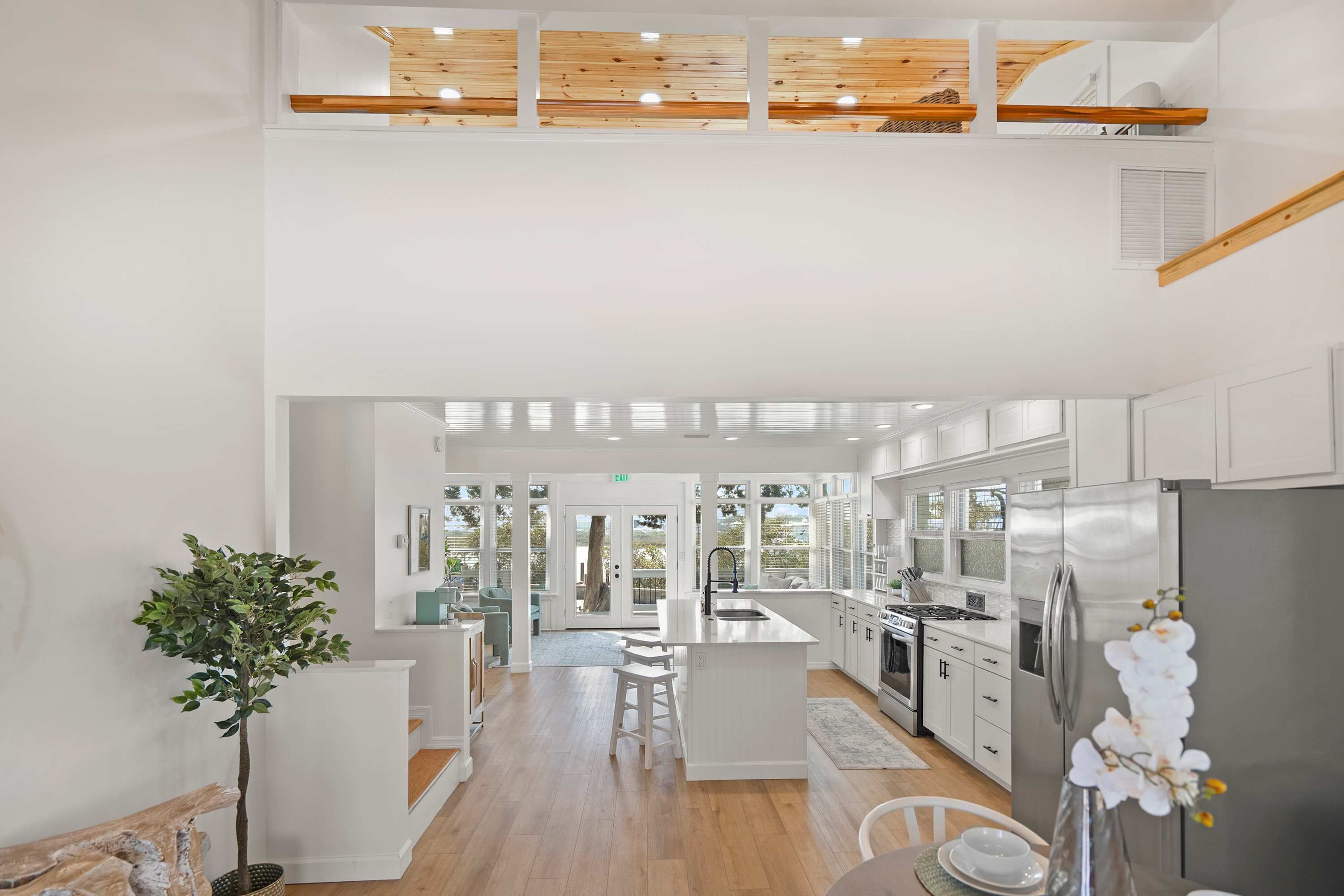 A modern kitchen with a central island, stainless steel appliances, and a view to the outdoors.