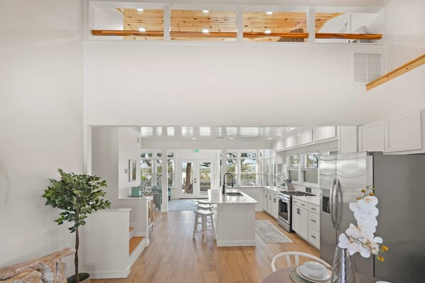 A modern kitchen with a central island, stainless steel appliances, and a view to the outdoors.