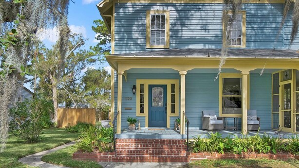 A two-story house with a front porch, a brick entrance, and a number '120' on the door. - Historic in Downtown St Aug Steps to Ice Plant (St. Augustine)