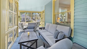 A covered porch with a sofa, chairs, and a table. - Historic in Downtown St Aug Steps to Ice Plant (St. Augustine)