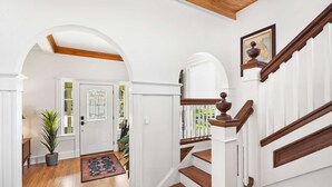 A staircase with wooden steps and white railings, leading to a door with glass panels. - Historic in Downtown St Aug Steps to Ice Plant (St. Augustine)