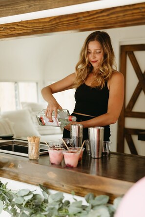 A person pouring a drink into a shaker on a wooden bar counter. - Stay in A Castle In St Augustine Hot Tub Fireplace (St. Augustine)