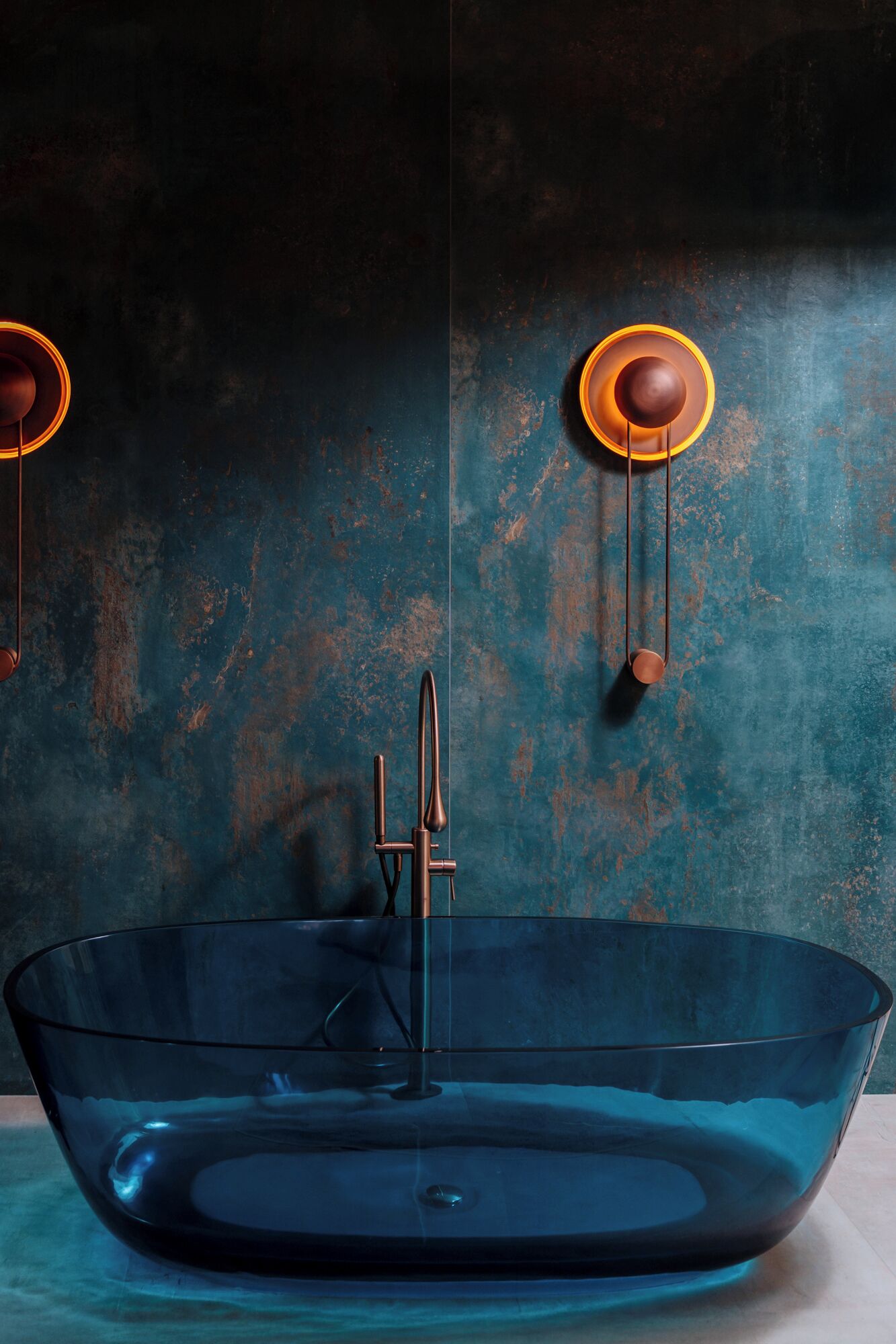 Un baño moderno con un lavabo de vidrio transparente y un grifo de diseño minimalista.