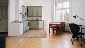 A kitchen with a dining area, wooden flooring, and a view of the outside. - Vintage 1BR Apt in Kamppi  (Helsinki)