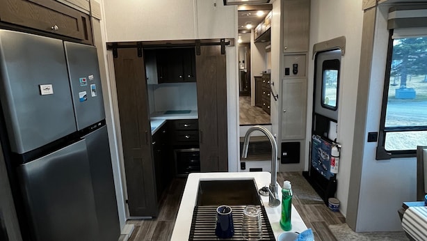 A modern kitchen with a central island, stainless steel appliances, and a view of the outdoors. - Luxury 1-bedroom RV with AC, WiFi in charming Bonavista (Bonavista)