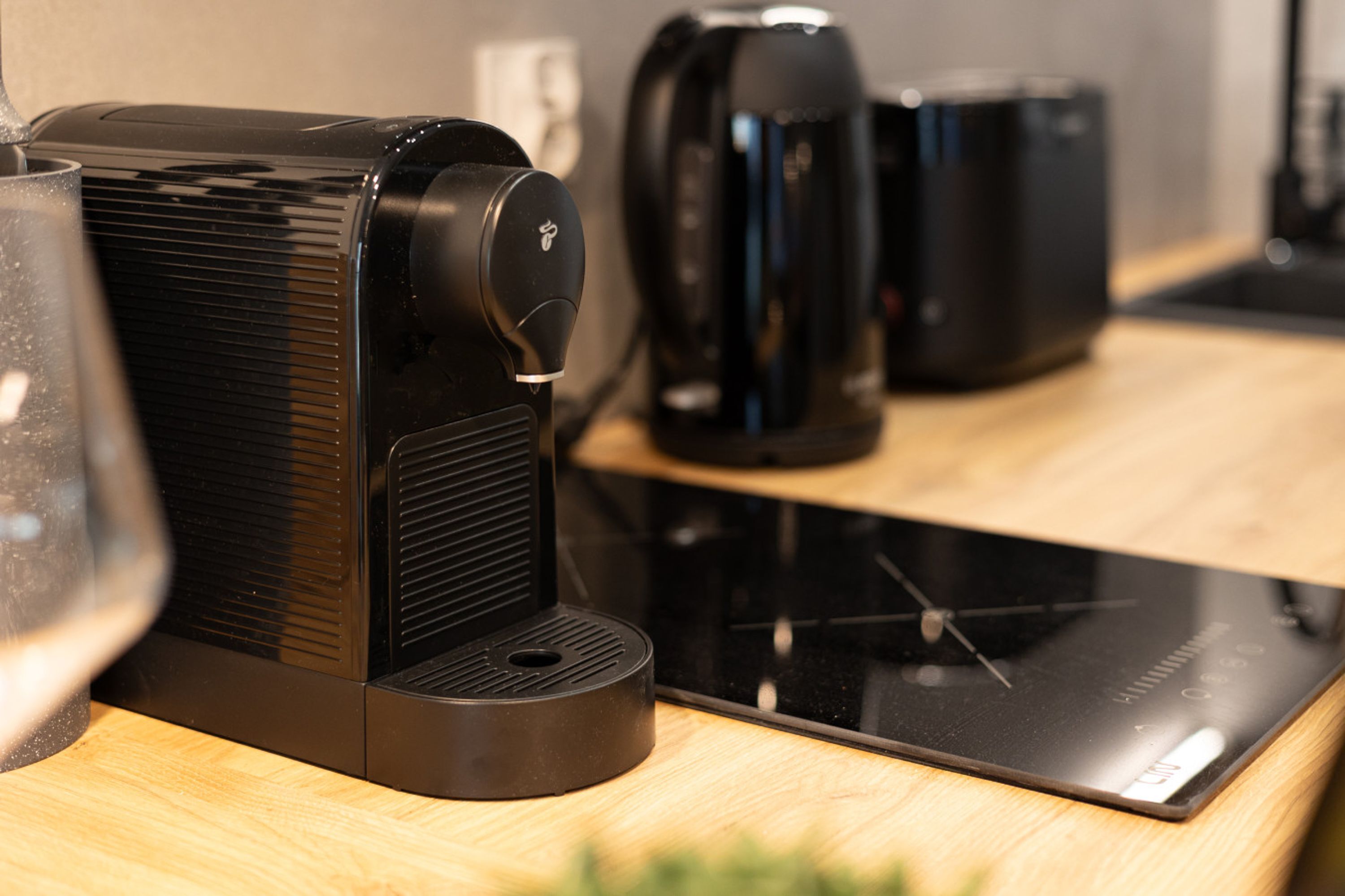 A kitchen with a coffee maker, a kettle, and a toaster on the counter.