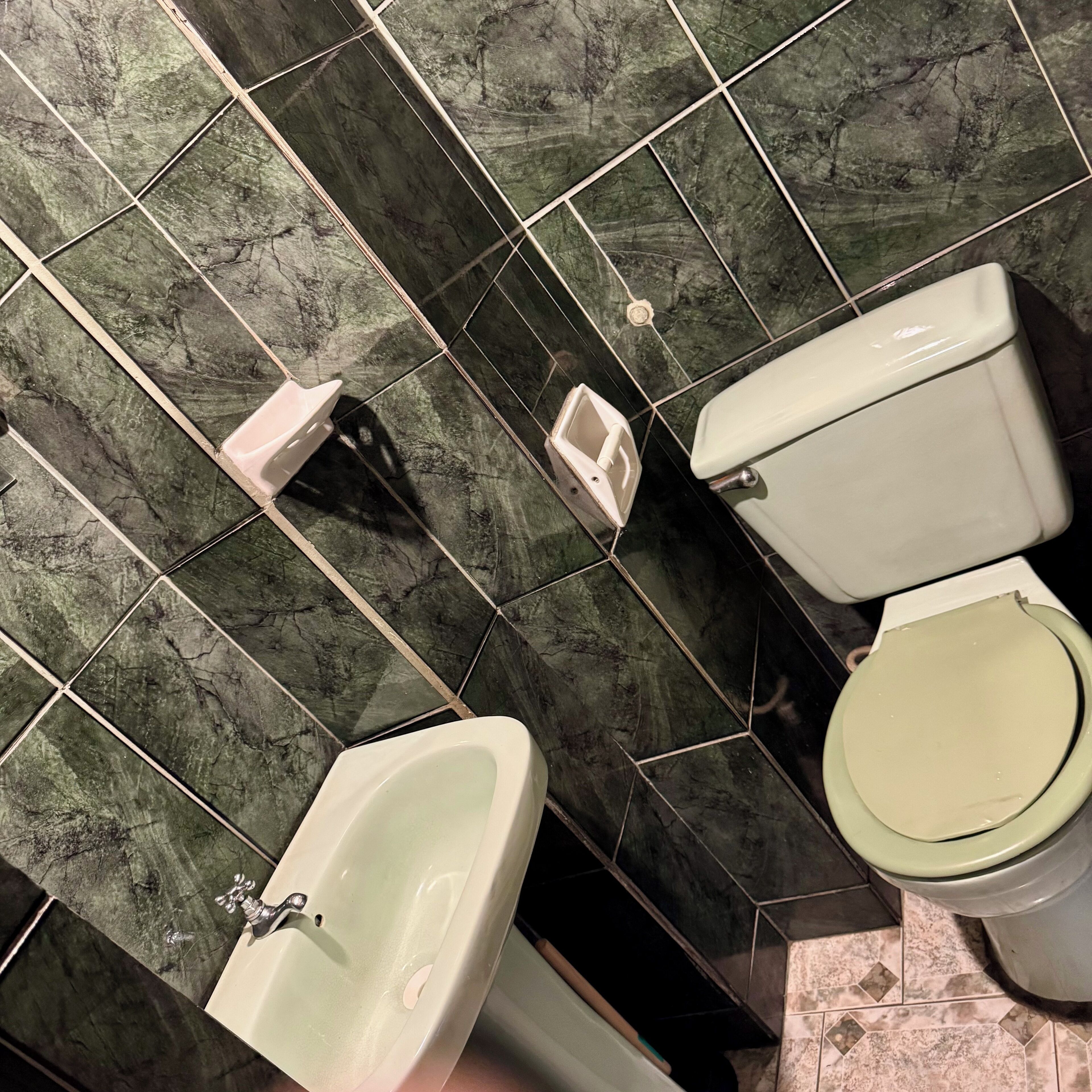 Un baño con bidé, inodoro y lavamanos.