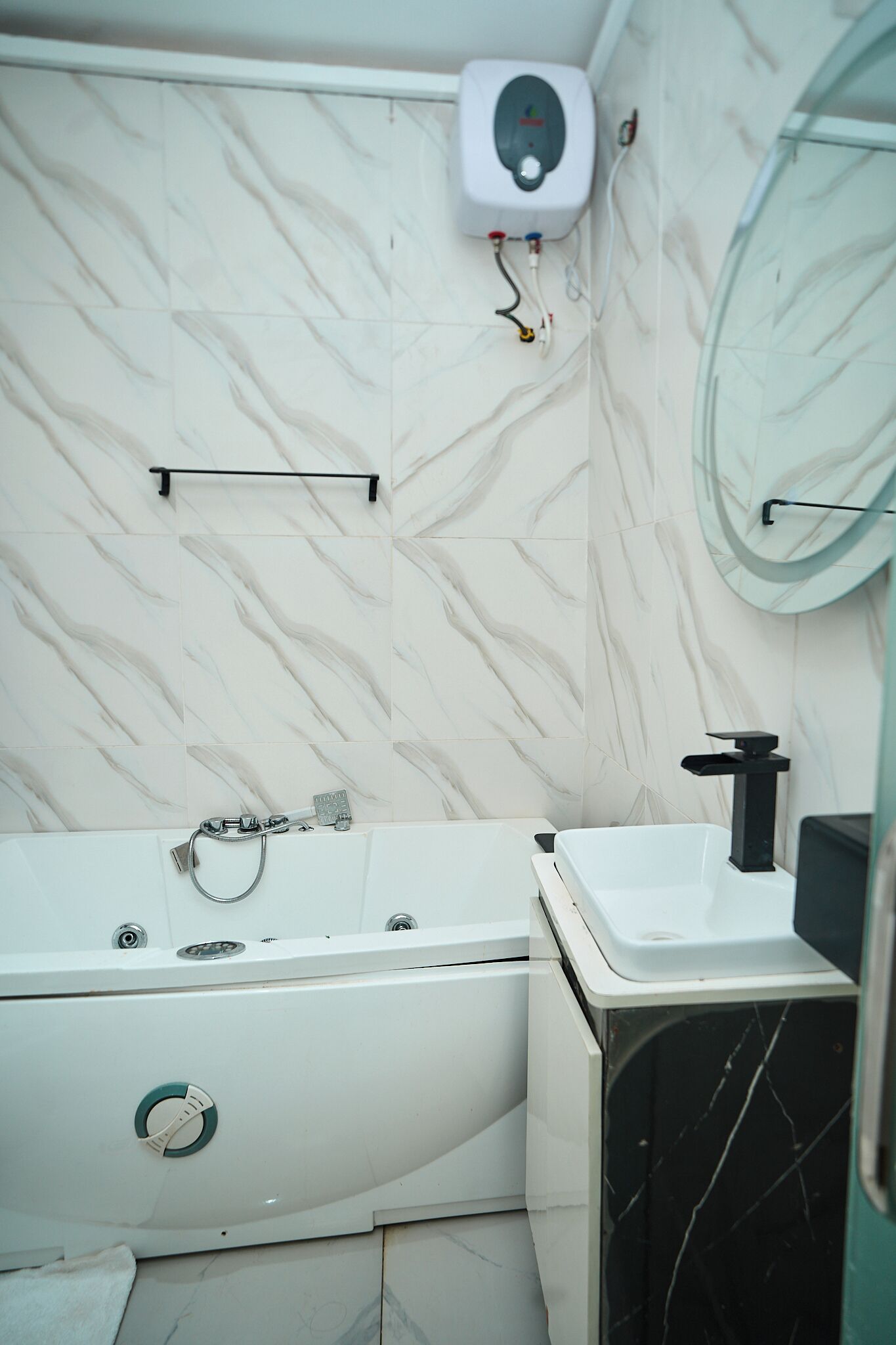 A bathroom with a white bathtub, a white sink, and a wall-mounted toilet.