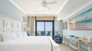 A hotel room with a large bed, a desk, a chair, and a view of the ocean. - Phoenix Gulf Shores Ii 1604 3 Bedroom Condo (Gulf Shores)