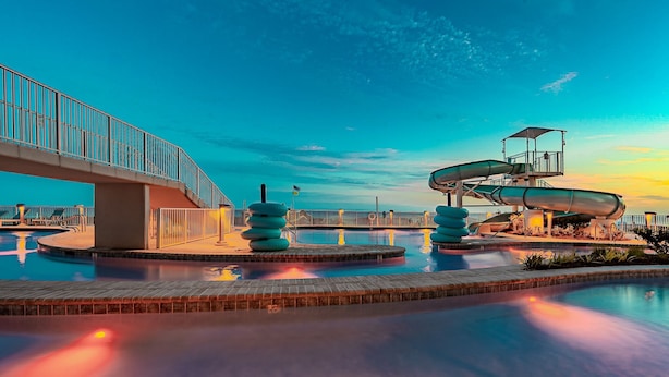 A water park with a bridge, slides, and a pool. - Phoenix Gulf Shores Ii 2003 3 Bedroom Condo (Gulf Shores)