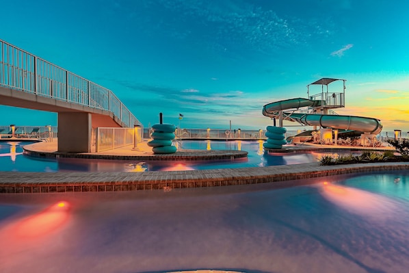 A water park with a bridge, slides, and a pool. - Phoenix Gulf Shores Ii 2104 3 Bedroom Condo (Gulf Shores)