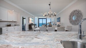 A spacious kitchen with a large marble island, modern appliances, and a view to the outside. - Phoenix Gulf Shores Ii 2003 3 Bedroom Condo (Gulf Shores)