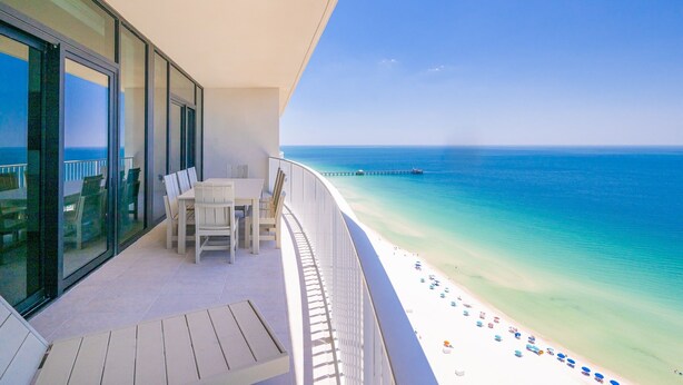 Un balcon avec vue sur une plage et l’océan.