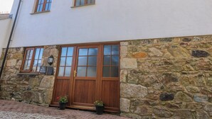 A two-story building with a stone facade and a wooden front door. - The Baler House (Hayle)