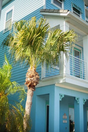 A blue building with a palm tree in front. - Margaritaville Themed +HotTub - 10min - Disney (Kissimmee)