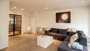 Ein modernes Wohnzimmer mit einer Couch, einem Couchtisch und einem Gemälde an der Wand.