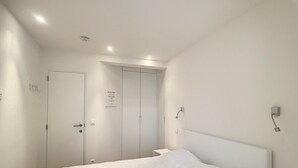 Ein Schlafzimmer mit einem großen Bett, einem Kleiderschrank und einer Tür mit einem motivierenden Spruch.