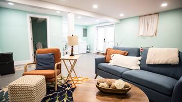Un salon comprenant un canapé, un fauteuil, une table basse et un petit tapis.