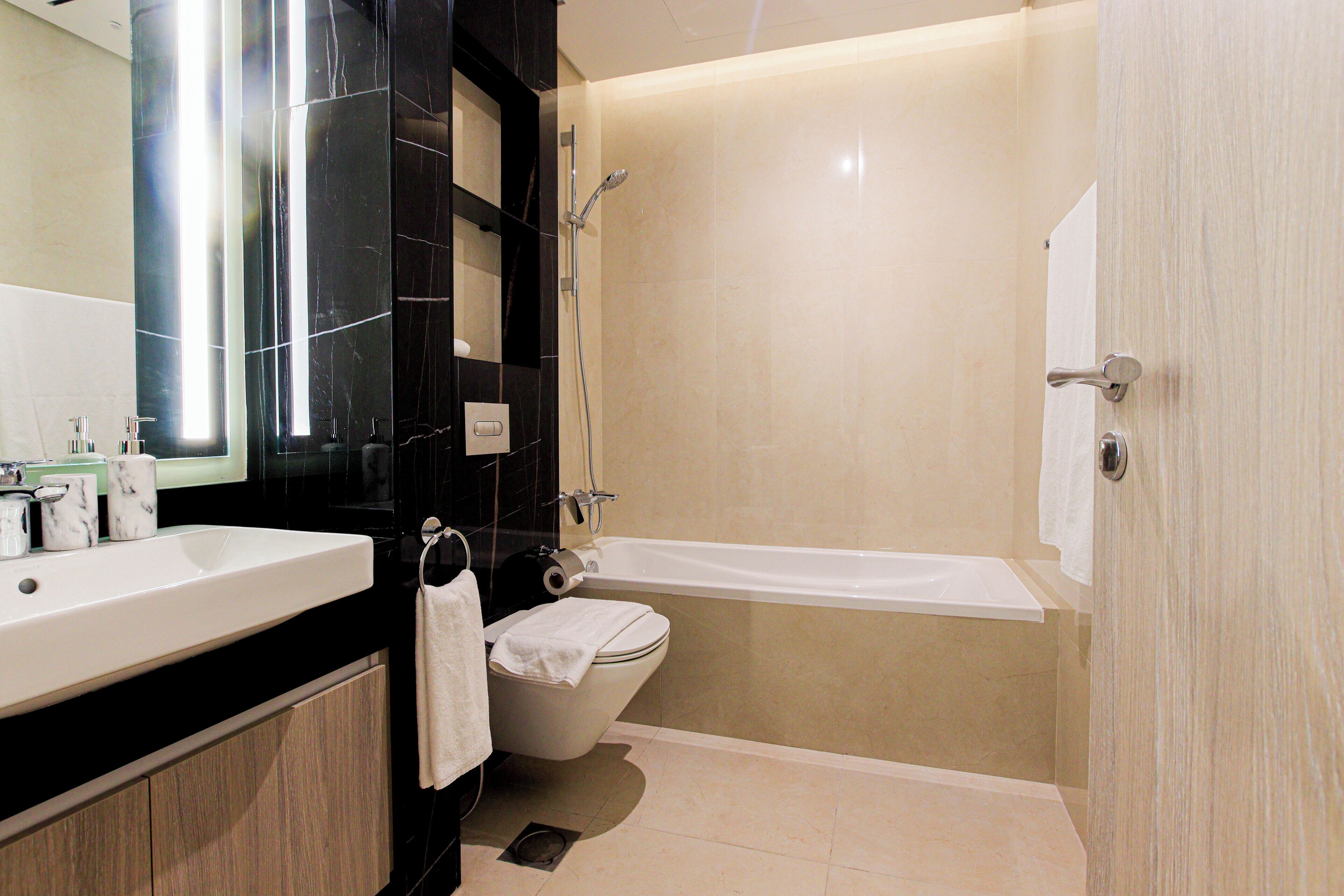 A modern bathroom with a large sink, toilet, and bathtub.