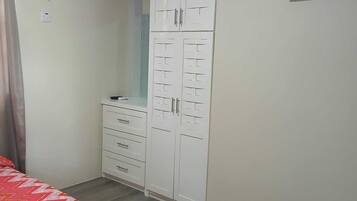 Ein Schlafzimmer mit einem Bett, einem Kleiderschrank und einer Klimaanlage.