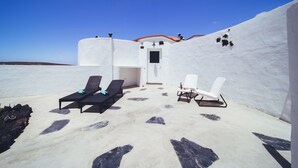 A rooftop terrace with two lounge chairs, a small table, and a door leading to an interior space. - Casa Natura 23 (San Bartolomé)
