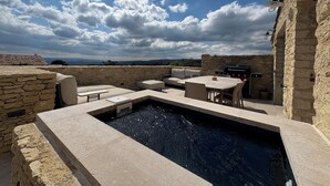 An outdoor patio with stone walls, a pool, and a barbecue area. - Soothing Provençale 3-bedroom house with WiFi in picturesque Gordes (Gordes)