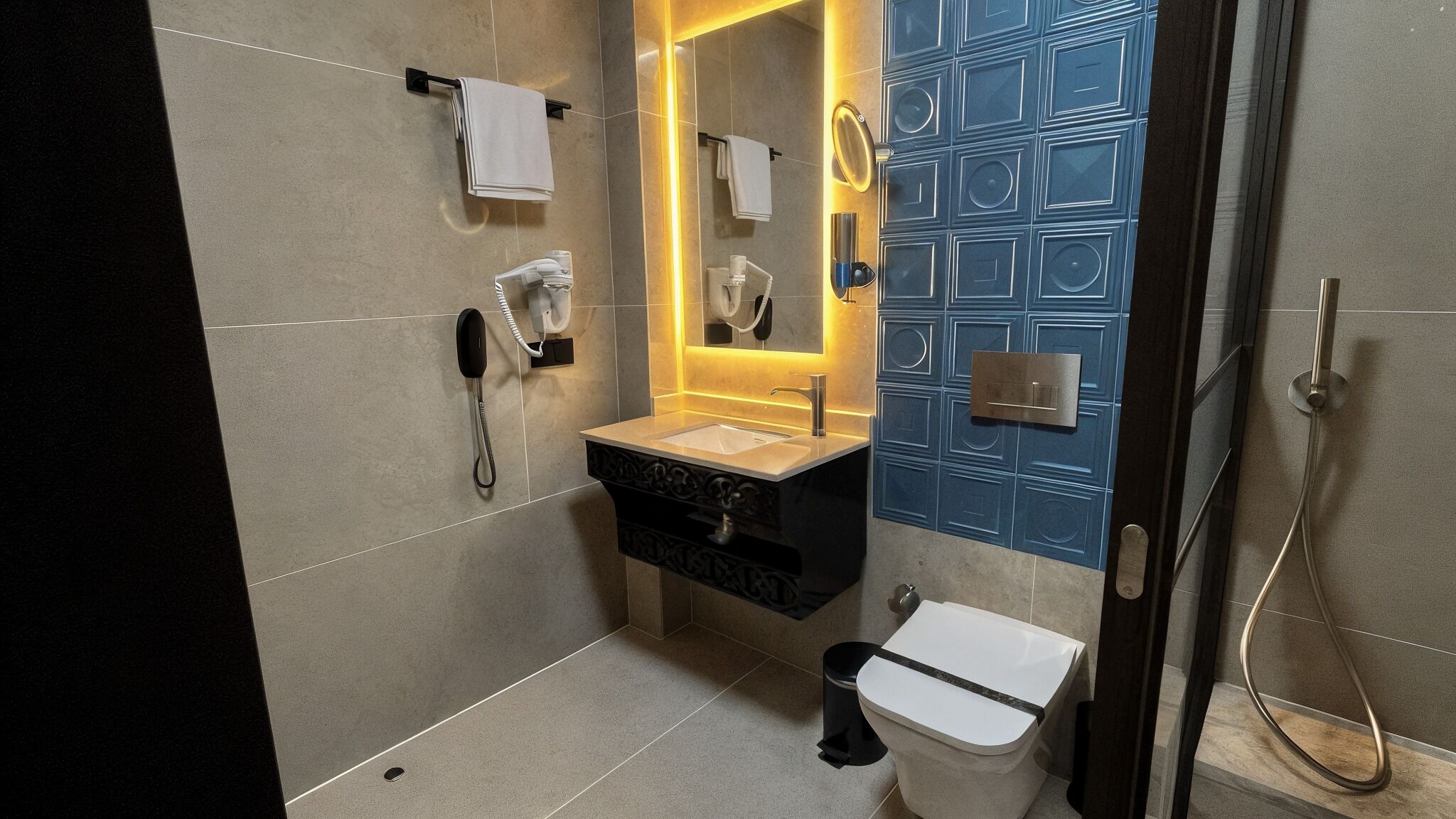Een moderne badkamer met een wastafel, toilet, douche en telefoon.
