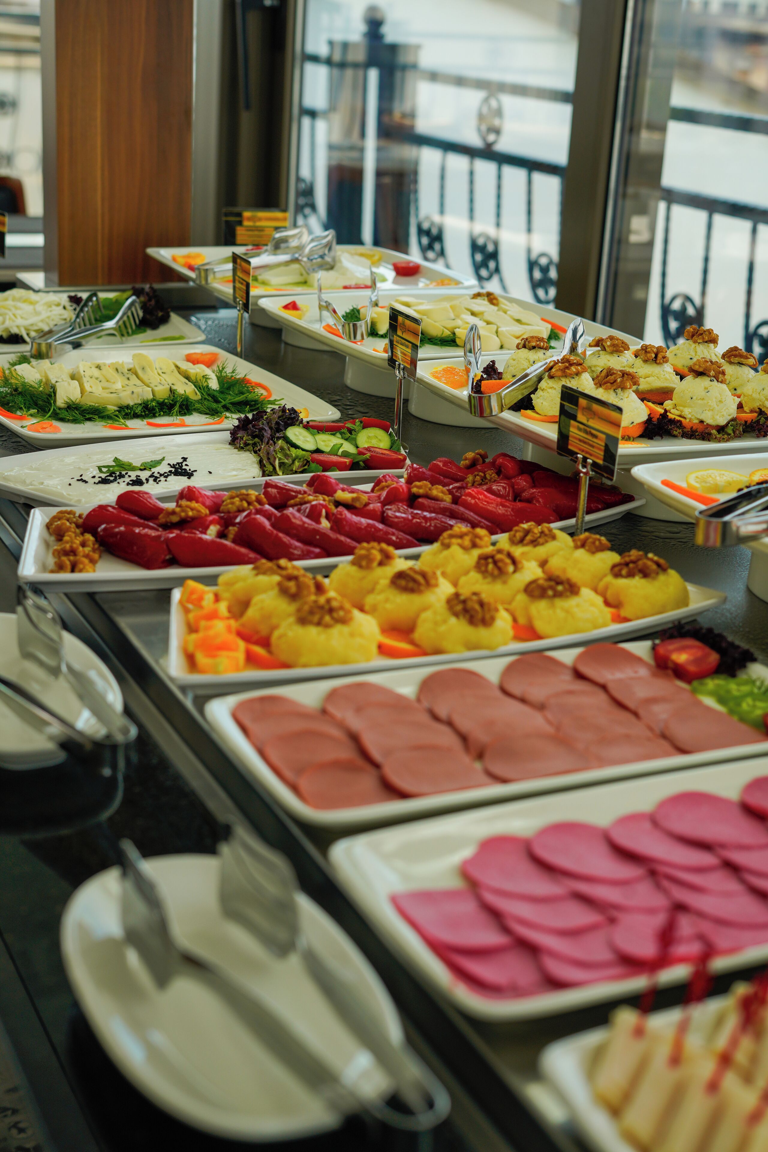 A buffet with various food items including meats, fruits, and vegetables.