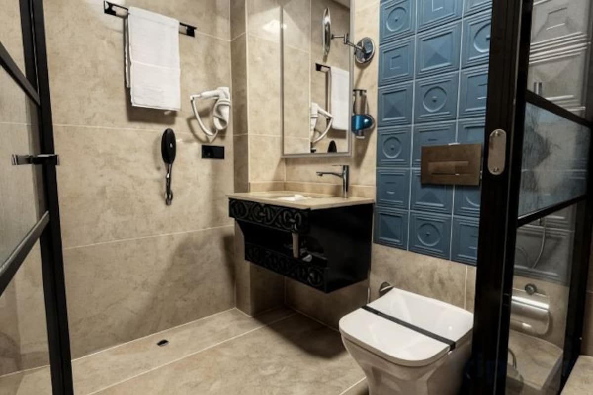 A bathroom with a toilet, sink, and mirror.