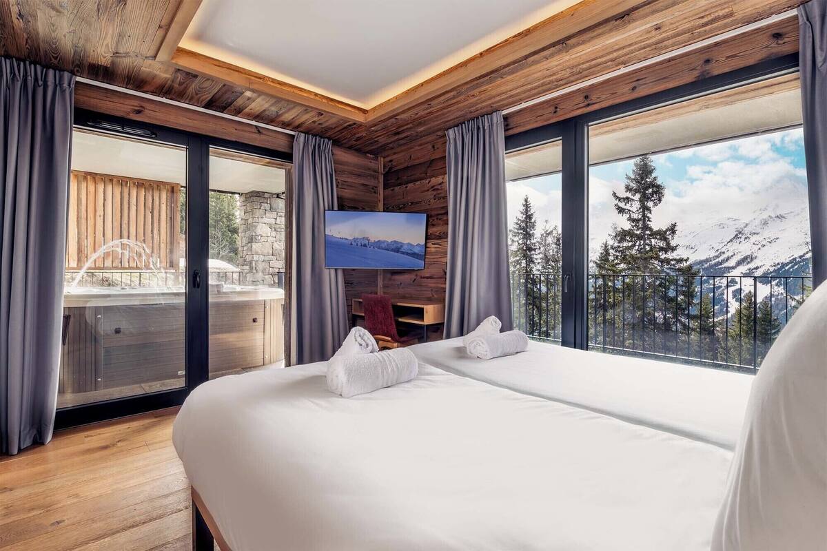 Ein Schlafzimmer mit einem großen Bett, einem Fernseher und Bergblick.