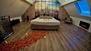 A bedroom with a large bed, a cityscape mural, a skylight, and a fireplace. - Loft Terre Jacuzzi and sauna Gravelines (Gravelines)