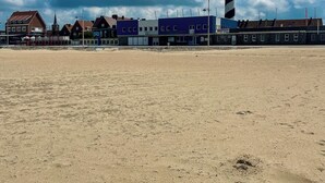 A beach with a lighthouse, buildings, and a church. - Loft Terre Jacuzzi and sauna Gravelines (Gravelines)