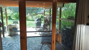 A covered patio with a patterned floor, a dog, and outdoor furniture.