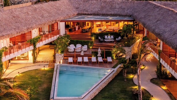 A resort with a pool, outdoor seating, and a thatched-roof structure. - Casa Siará - Preá (Cruz)