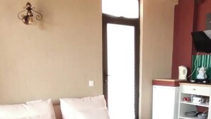 Uma sala de estar com sofá, mesa de centro e televisão.