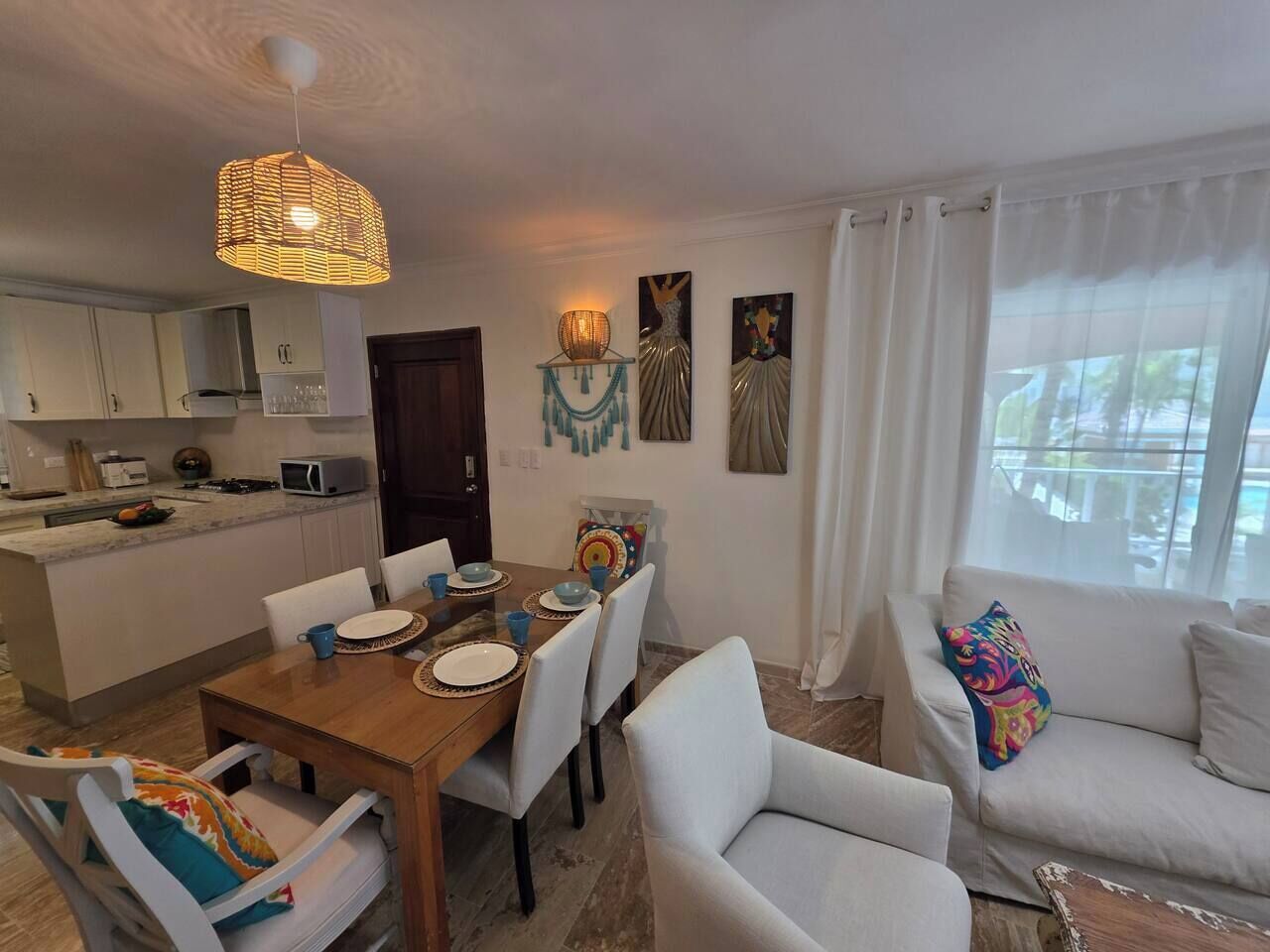 Ein modernes Wohnzimmer mit Essbereich, einer Couch und einer Küche im Hintergrund.