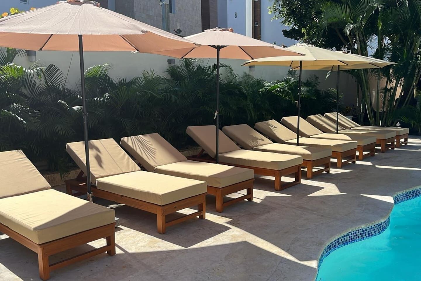 Un espace aménagé au bord de la piscine, avec des chaises longues et des parasols.