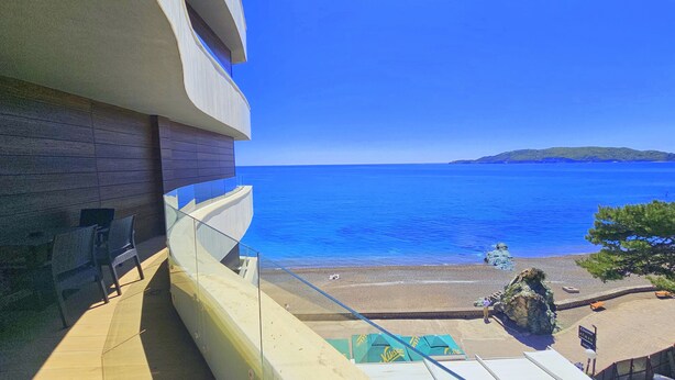 A balcony with a view of the sea and a beach. - Royalis Suites Rafailovici - Beachfront Sea View Apartments (Becici)