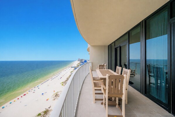 A balcony with a view of a beach and ocean.