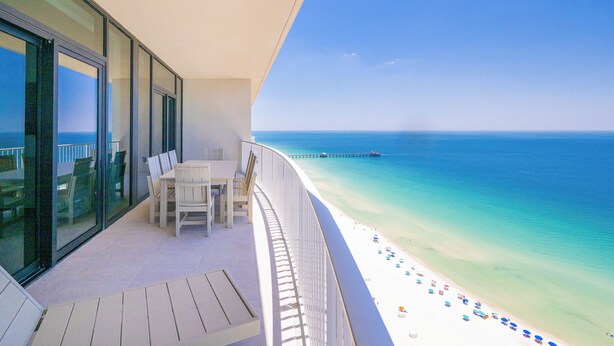 A balcony with a view of a beach and ocean.