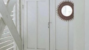 A white door with a sunburst mirror and a doormat. - Large Common Areas, Quiet Street, Golf Cart Available! (Carolina Beach)