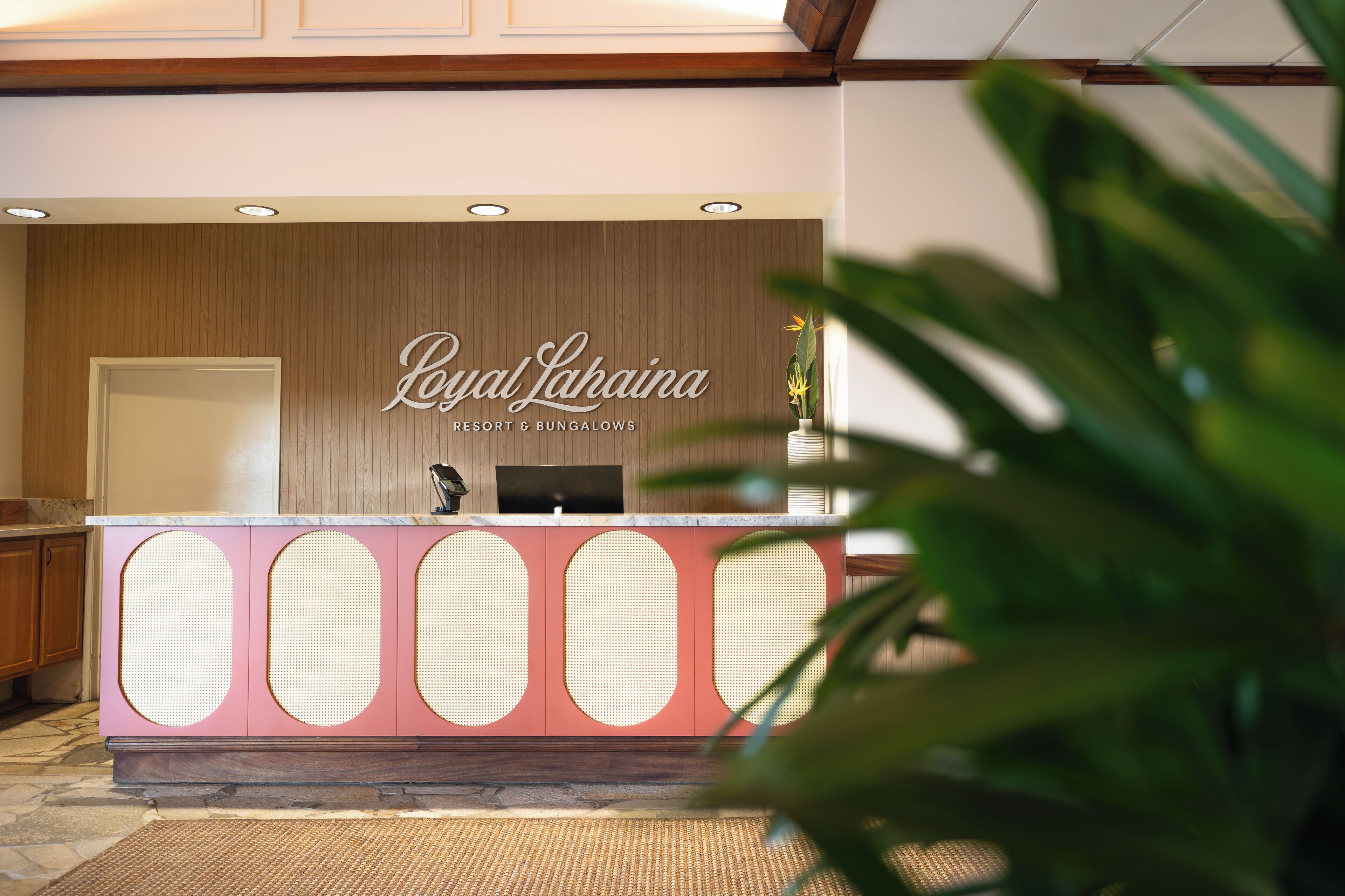 A reception desk with a sign reading "Royal Lahaina Resort & Bungalows".