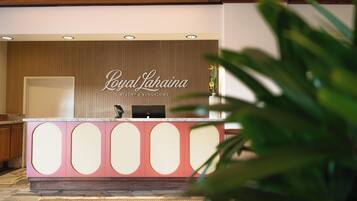 A reception desk with a sign reading "Royal Lahaina Resort & Bungalows".