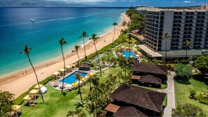 Un resort con playa, piscina y un edificio grande.