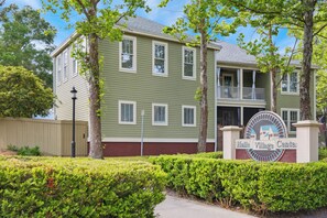 A two-story building with a green facade, a balcony on the second floor, and a sign reading "Haile Village Center".