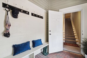 Enter a welcoming space with a cozy bench and staircase leading to a comfortable ascent.
