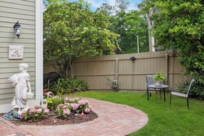 Enjoy a serene outdoor space with a curved pathway, seating area, and lush greenery.