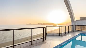 Una piscina al aire libre, sombrillas, sillones reclinables de piscina