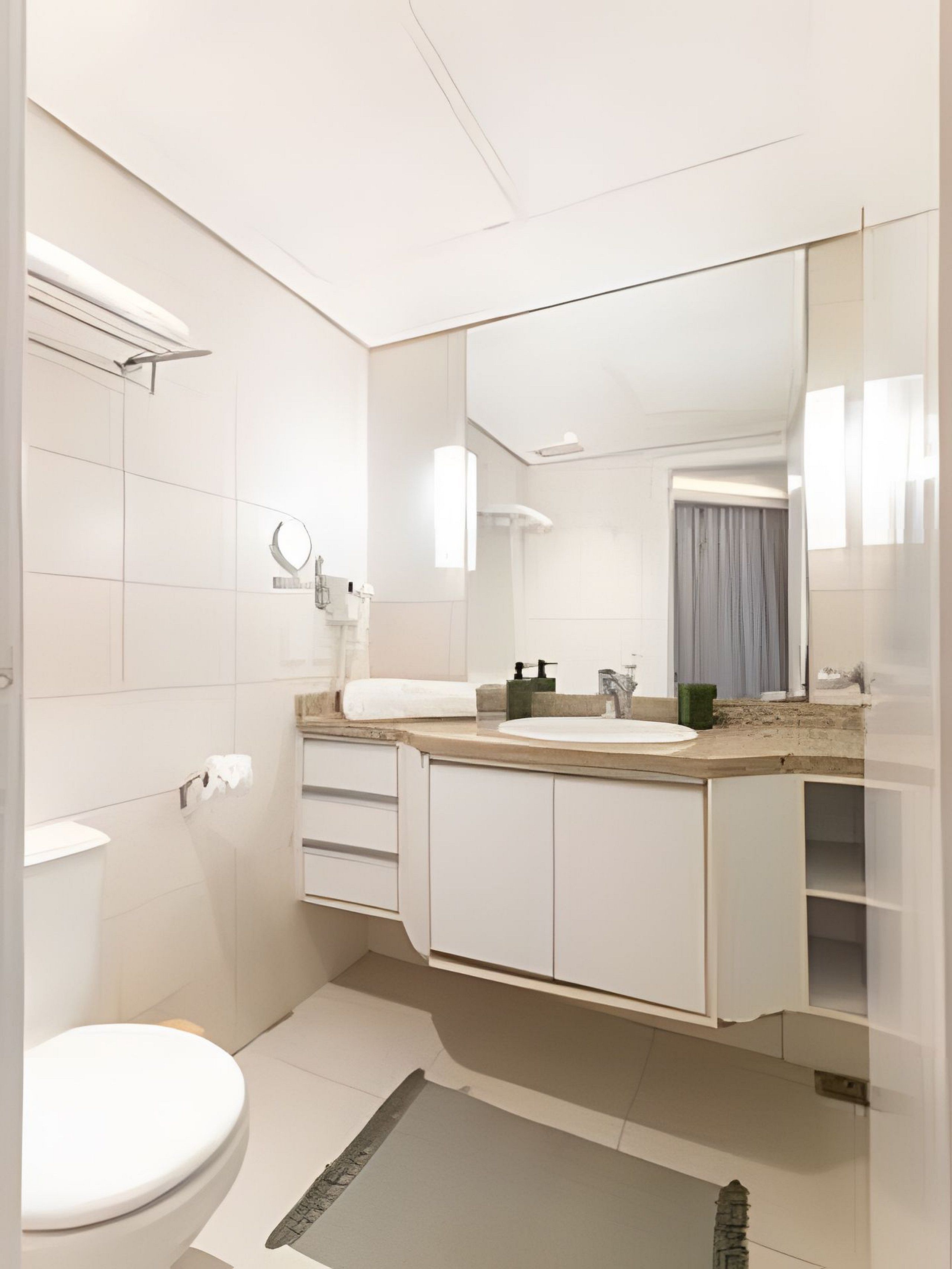 Un baño moderno con inodoro, lavabo, espejo y ducha.