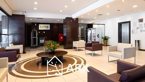 Un vestíbulo moderno con una mesa de centro, zona de estar y mostrador de recepción.